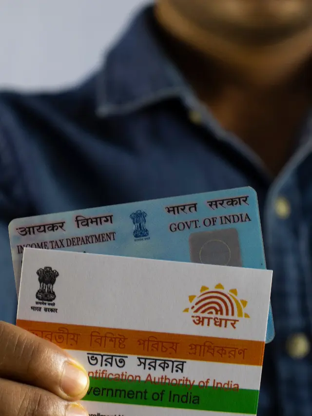 a man holding pan card and Aadhar card ,link pan card and Aadhar card